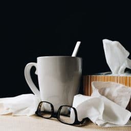 A mug, a pair of glasses and some tissues.