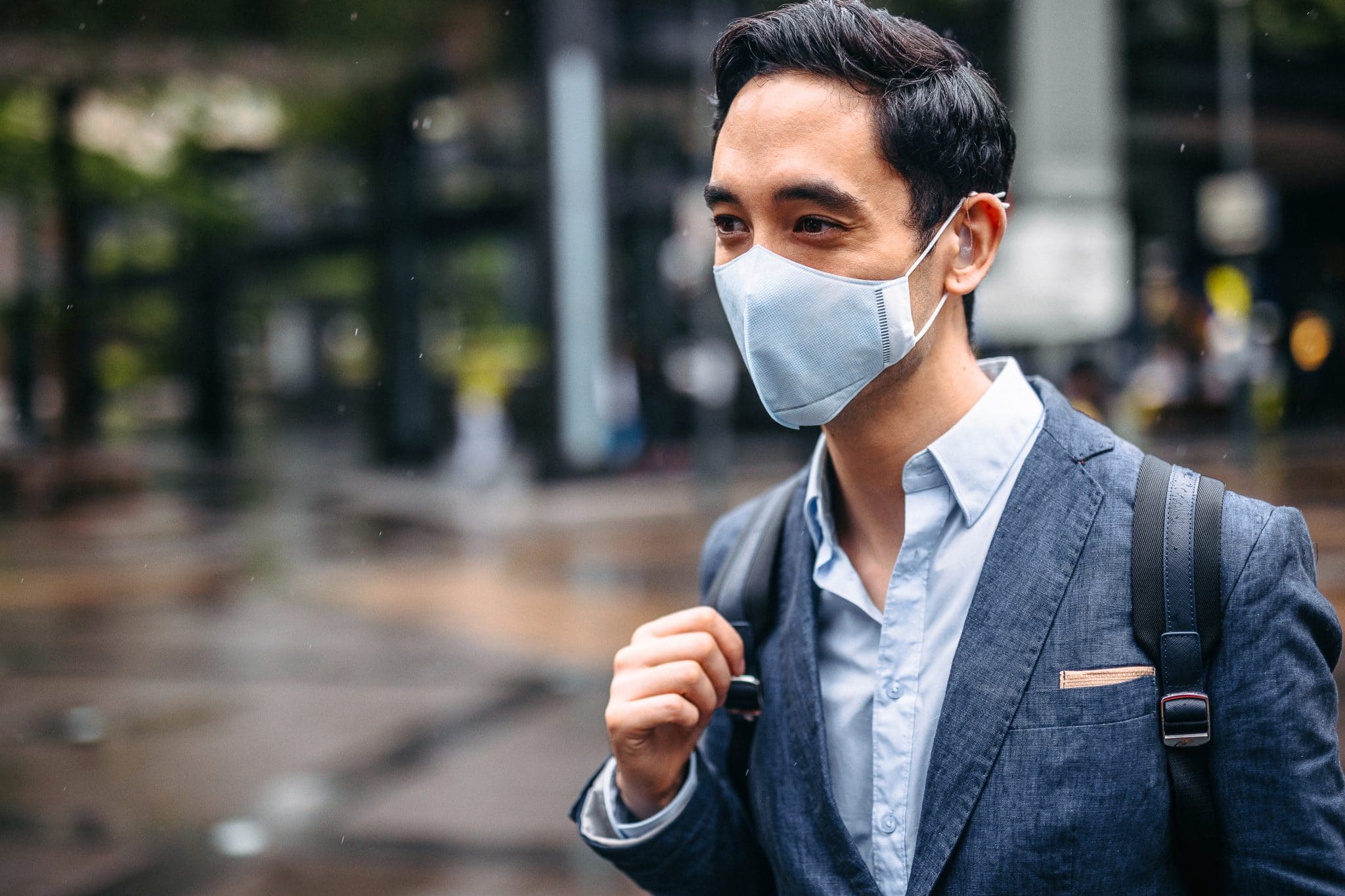 Businessman wearing mask and hearing aid.