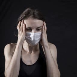 Woman wearing a mask in distress