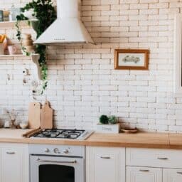 A lovely ranch-style kitchen with a white brick wall and brick cabinets.