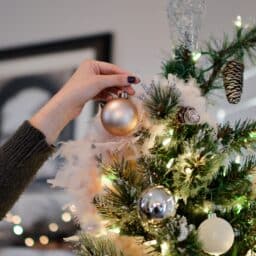 Close up of a woman decorating her Christmas tree.