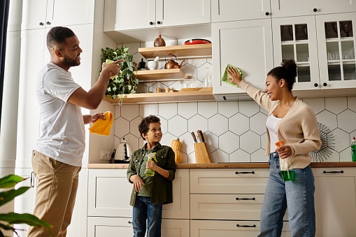 Happy family cleaning the kitchen together as part of spring cleaning.